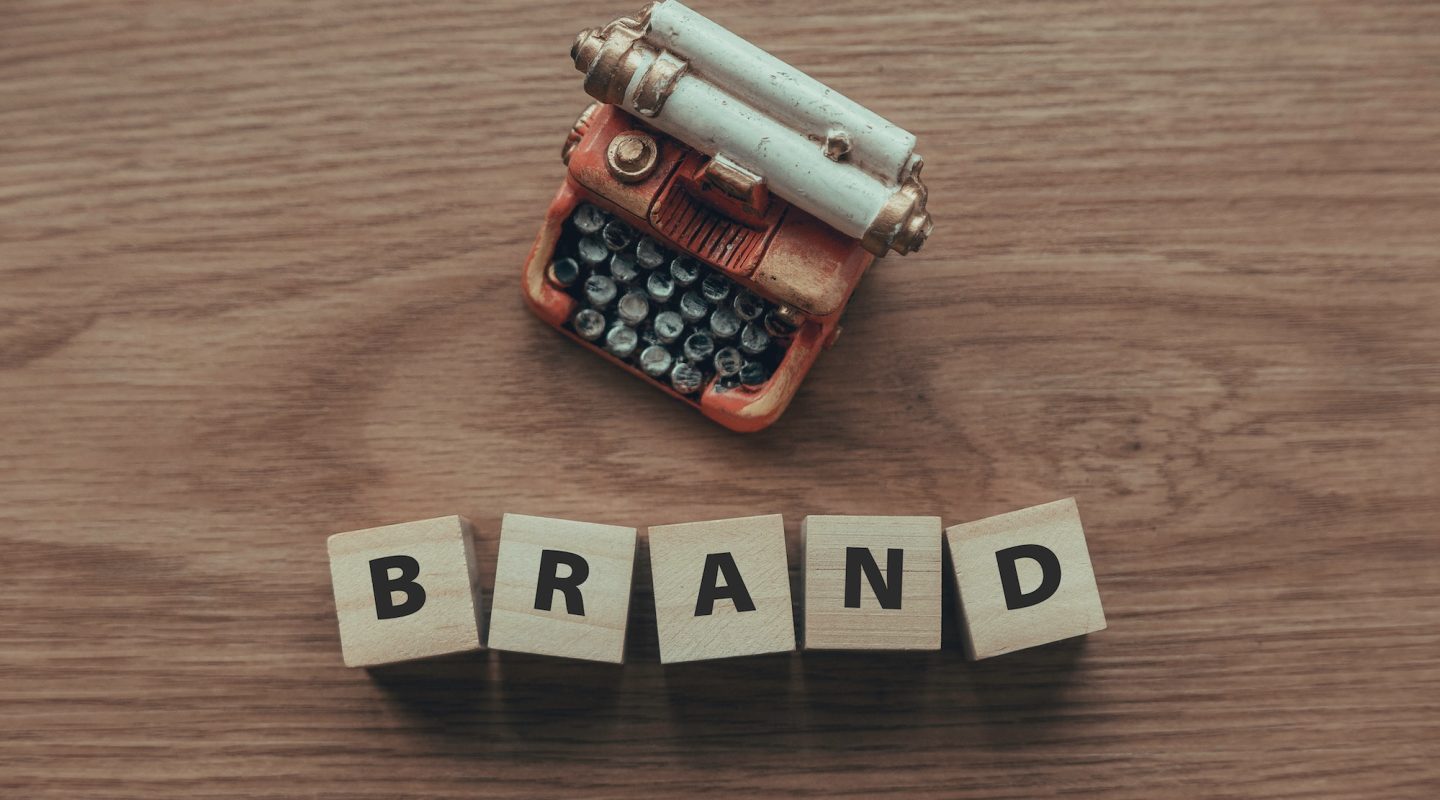 top-view-of-typewriter-and-wooden-cube-with-text-brand-on-wooden-background-.jpg